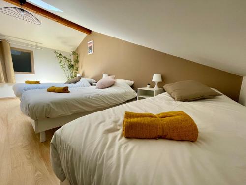 a bedroom with two beds with towels on them at BnGo I Maison Terracotta I Jardin, Garage, 3 chambres, 9 personnes in Villeurbanne