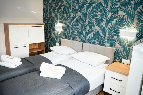 a bedroom with two beds and a green and white wallpaper at Apartamenty Cicha - bezpłatny parking in Krynica Zdrój