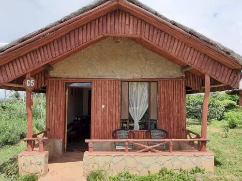 a small house with a thatched roof at AA Lodge Amboseli in Amboseli