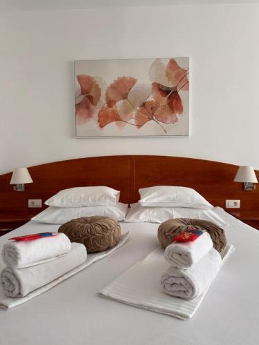 a white bed with towels on it with avertisement at ''ROOM 6'' - breakfast included in Kampor