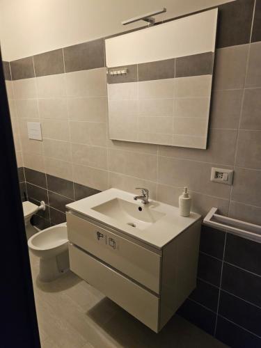 a bathroom with a sink and a toilet and a mirror at B&B Via Nazionale in Milazzo