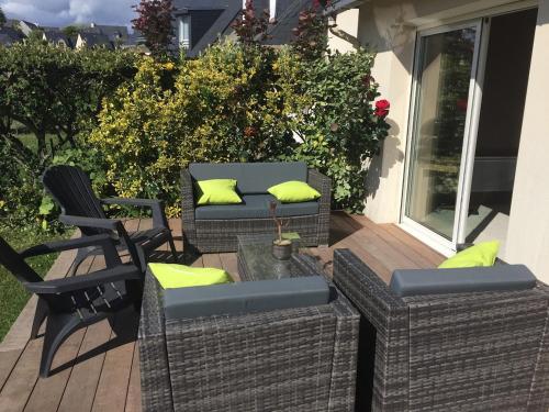 two wicker chairs and a couch on a deck at Le Cocon Iodé - 100m des plages-GR34-skatepark-kite-surf-voile-terrasse-jardin in Clohars-Carnoët