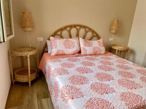 een slaapkamer met een bed met roze en witte lakens en kussens bij Casa Marisol in Orosei