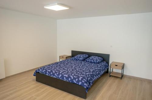 une chambre avec un lit avec une couette bleue dans l'établissement Loft cosy au cœur du village, à Wissous