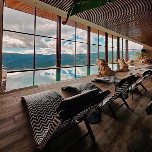 a room with a table and chairs and a large window at Encosta de Louredo by Pousadela Village in Vieira do Minho