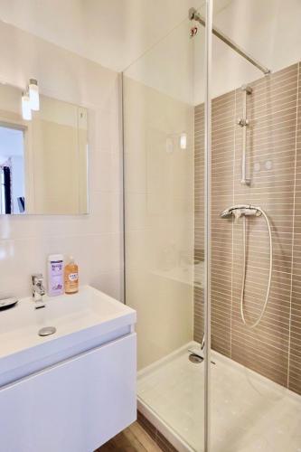 une salle de bain blanche avec une douche et un lavabo dans l'établissement Studio with Big terrace full center with air conditioning, à Nice