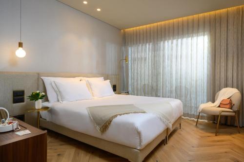 a bedroom with a large white bed and a window at Jewel TLV Hotel in Tel Aviv