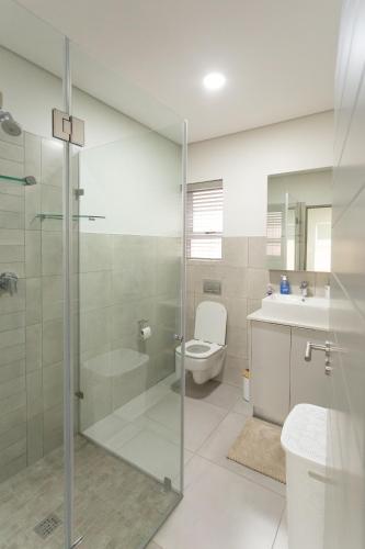 a bathroom with a shower and a toilet and a sink at Group House 2 - 1 On York in George