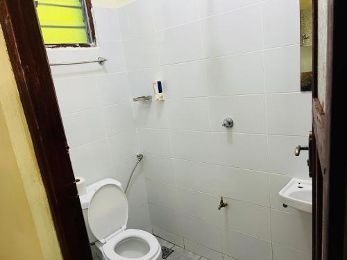 a bathroom with a toilet and a sink at Kiv haven homes, old ferry studios in Kilifi