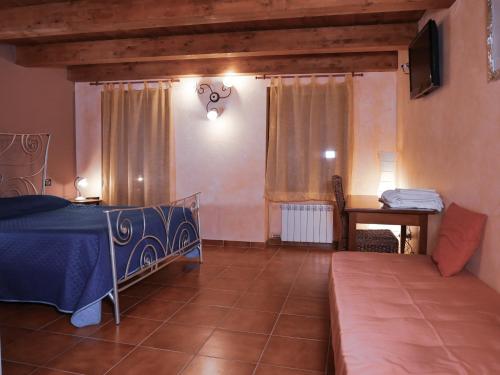a bedroom with a bed and a table and a couch at Perbacco in SantʼAngelo Limosano