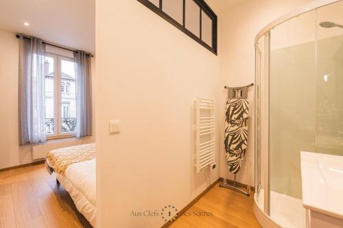 une chambre avec un lit et une douche en verre dans l'établissement A deux min de la cathédrale T2 Premium Rue Libergier, à Reims