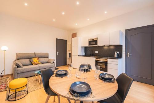 un salon avec une table, des chaises et un canapé dans l'établissement A deux min de la cathédrale T2 Premium Rue Libergier, à Reims