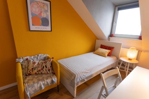 a small room with a bed and a chair at Big flat with fresh renovation, free parking, SonyPS, Netflix in Duisburg