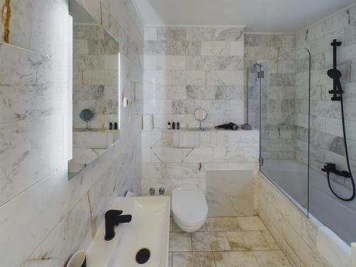 a bathroom with a tub and a toilet and a sink at Art Apartments in Hamburg