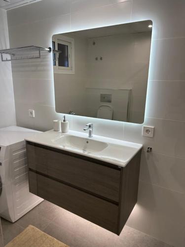 a bathroom with a sink and a large mirror at Beach apartment LA CALA DE MIJAS in La Cala de Mijas