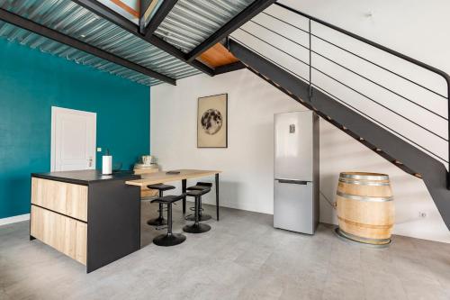 - une cuisine avec une table et un réfrigérateur dans la chambre dans l'établissement Loft chaleureux, à Cognac