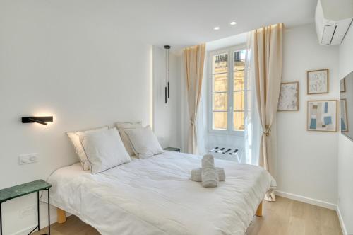 - une chambre dotée d'un lit blanc avec un ours en peluche dans l'établissement SIDI BRAHIM - Sublime appartement en centre-ville, à Menton