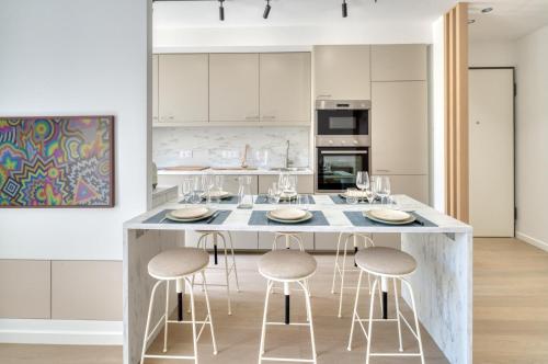 une cuisine avec un grand îlot et des tabourets de bar dans l'établissement SIDI BRAHIM - Sublime appartement en centre-ville, à Menton