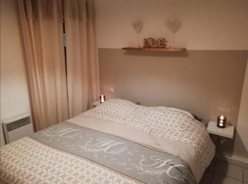 - un lit dans une chambre avec 2 bougies dans l'établissement L'Oasis de Jade - T2 avec terrasse - Piscine, à Saint Cyprien Plage