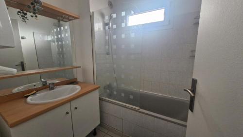 une salle de bain avec un lavabo et une douche dans l'établissement L'Oasis de Jade - T2 avec terrasse - Piscine, à Saint Cyprien Plage