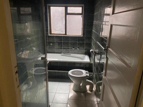 un baño con inodoro y bañera en SABATH LODGE, en Ciudad del Cabo