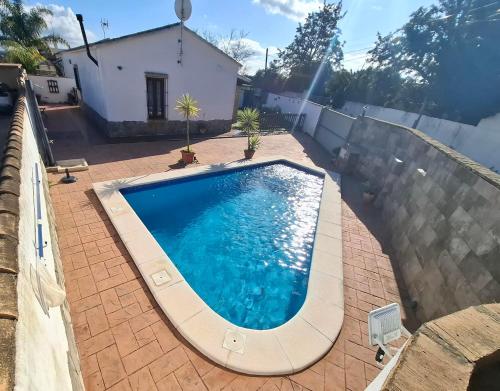 una grande piscina in un cortile con una casa di Cortijo El Almendro, Urb. Fuente del Gallo, Conil a Conil de la Frontera