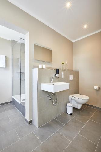 a bathroom with a sink and a toilet at Zum Landsberger Hof in Arnsberg