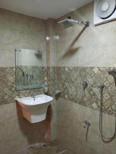 a bathroom with a sink and a shower at Cha Cha Guest House in Trincomalee