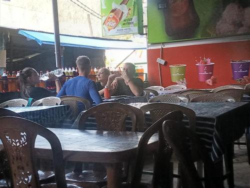 a group of people sitting at a table in a restaurant at Shan Hotel in Adams Peak