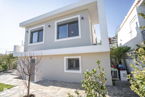 a white house with a lot of windows at 'Red Port'Amazing House 5 min from the sea in Rafina