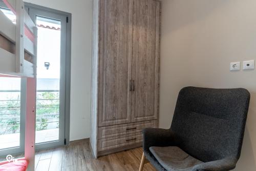 a bedroom with a wooden cabinet and a chair at 'Red Port'Amazing House 5 min from the sea in Rafina