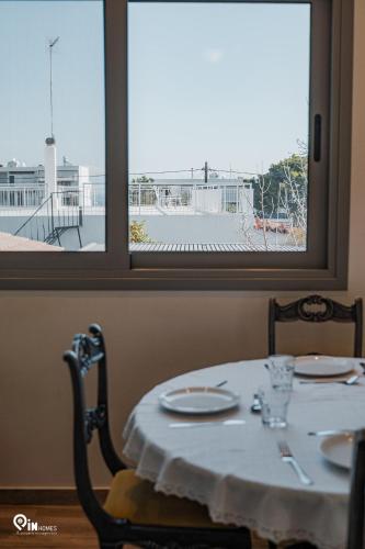 a table with two chairs and a table and a window at 'Red Port'Amazing House 5 min from the sea in Rafina