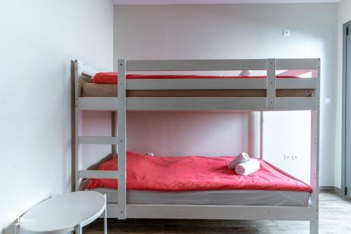 a bedroom with two bunk beds with a red blanket at 'Red Port'Amazing House 5 min from the sea in Rafina