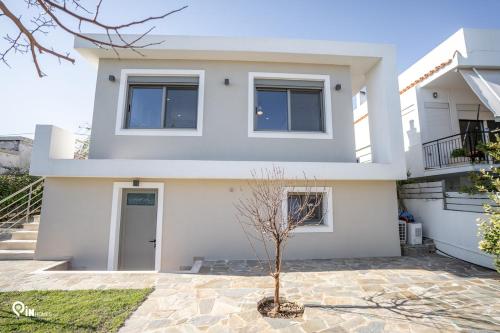 a white house with a tree in front of it at 'Red Port'Amazing House 5 min from the sea in Rafina