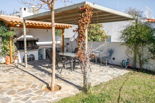 a patio with a table and a grill at 'Red Port'Amazing House 5 min from the sea in Rafina