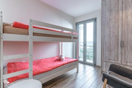 a bedroom with two bunk beds and a balcony at 'Red Port'Amazing House 5 min from the sea in Rafina