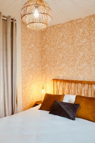 - une chambre avec un lit blanc et un lustre dans l'établissement Charming apartment - private parking, balcony, à Caen