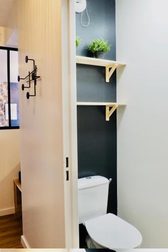 une salle de bain avec des toilettes blanches dans une chambre dans l'établissement Charming apartment - private parking, balcony, à Caen