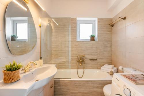 a bathroom with a tub and a sink and a mirror at Casa Loggia in Lixouri