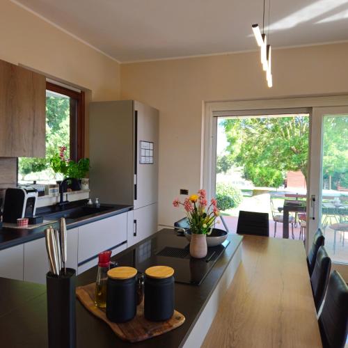 a kitchen with a table and a dining room at S'Home - Villa nel Verde fuori Roma - Alloggio Sostenibile in Aprilia