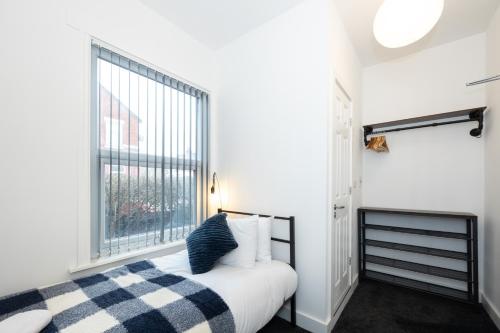 a bedroom with a bed and a large window at Private ensuite rooms with kitchen access by Irwell Stays in Manchester