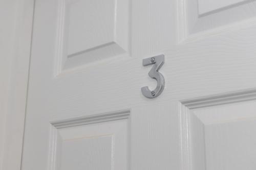a white door with the number on it at Private ensuite rooms with kitchen access by Irwell Stays in Manchester