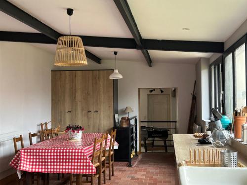 d'une salle à manger avec une table et un tissu de table rouge et blanc. dans l'établissement Les MADELEINE de GIEVRES, à Gièvres