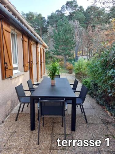 une table noire et des chaises sur une terrasse dans l'établissement Maison accueillante près de la Sainte-Baume, à Plan dʼAups