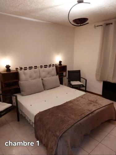 une chambre avec un grand lit et deux chaises dans l'établissement Maison accueillante près de la Sainte-Baume, à Plan dʼAups