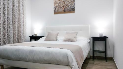 a bedroom with a large white bed with two tables at Black Horse in San Giorgio a Cremano