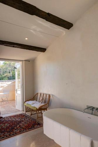 - une baignoire dans une chambre avec un banc dans l'établissement Idyllic Riverside Provencal Farmhouse, au Thoronet