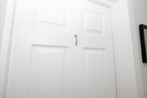 a white closet with a door in a room at Private ensuite rooms with kitchen access by Irwell Stays in Manchester