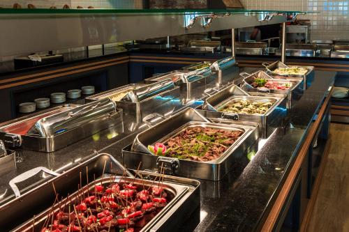 una cucina con un sacco di vassoi di cibo di Villa Sunflower Hotel - All Inclusive a Alanya