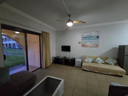 ein Wohnzimmer mit Sofa und Fernseher in der Unterkunft 16 Cabanas Del Mar Winklespruit KZN South Coast in Kingsborough